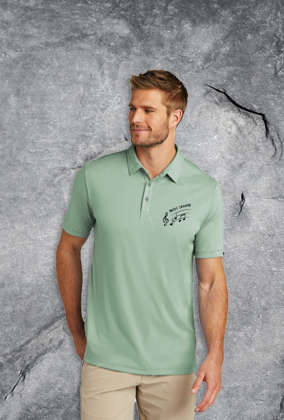 Man wearing a pale green polo decorated with a music logo for Nashville, Tennessee.